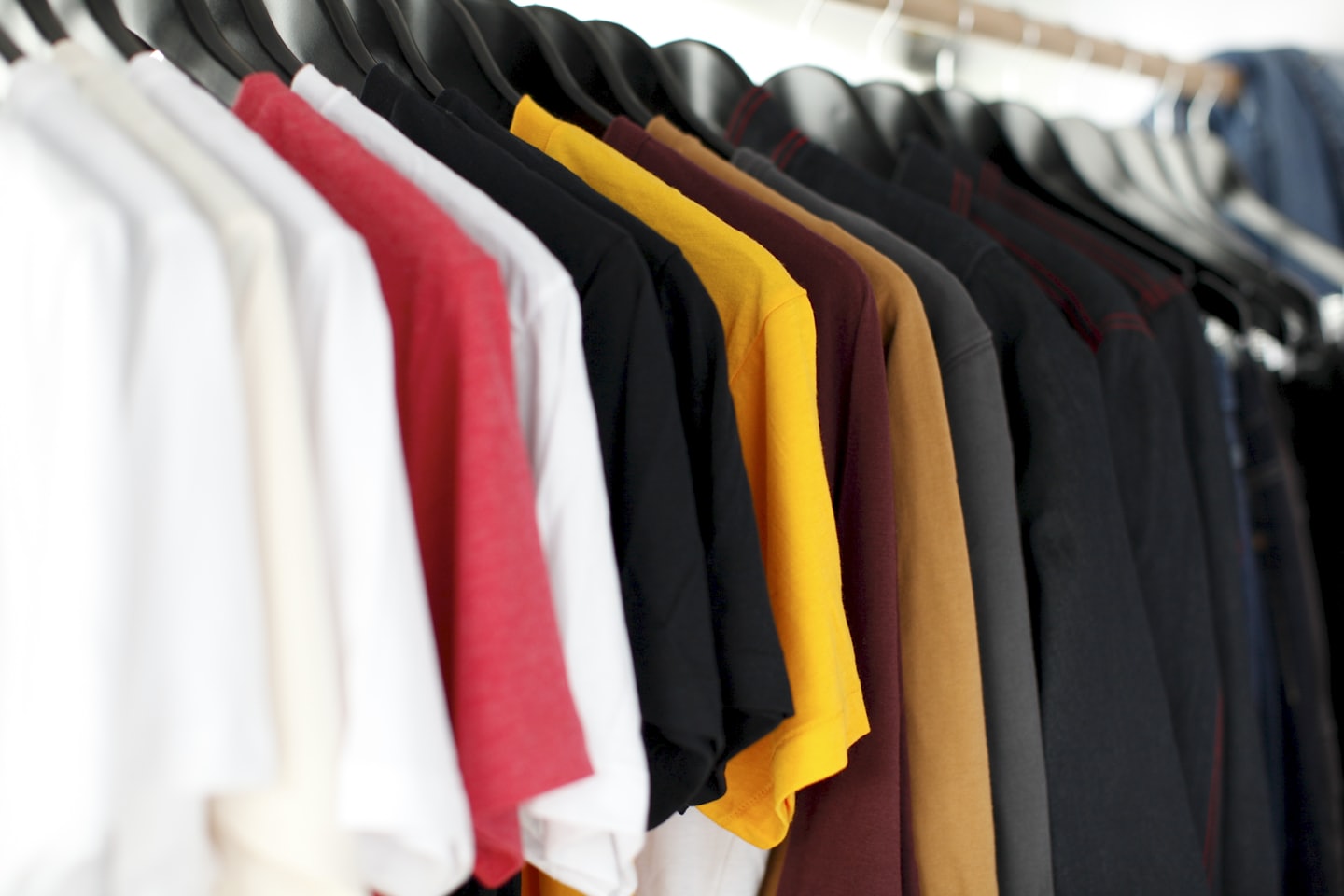Home Colorful shirts and clothing hanging on a rack